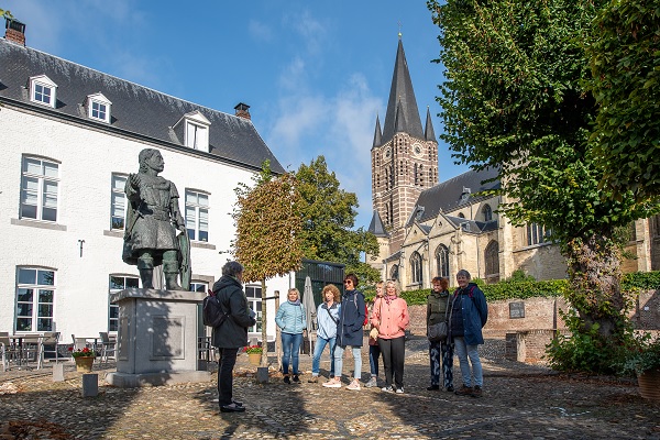 Eine Besuchergruppe erhält eine Führung durch Thorn mit der Abteikirche im Hintergrund
