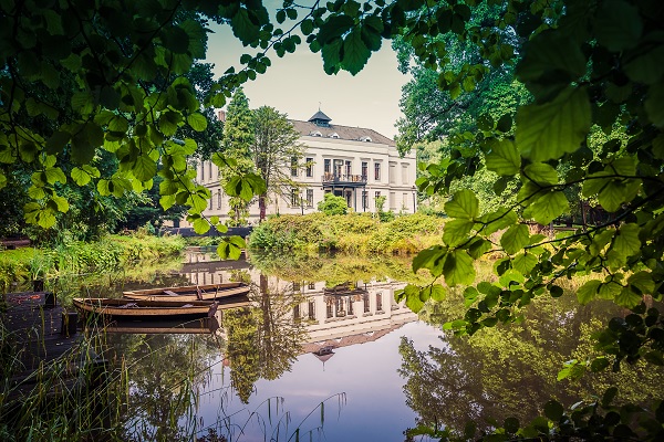Schloss de Berckt durch ein Vordach gesehen mit dem Teich im Vordergrund